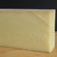 Block of pale yellow French Raclette cheese ideal for melting and enjoying with dishes