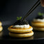 Caviar-topped blini stack showcasing a gourmet food house caviar recipe read