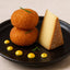 Stacked fried cheese balls with cheese wedge made from Petit Basque Cheese from the French Pyrenees